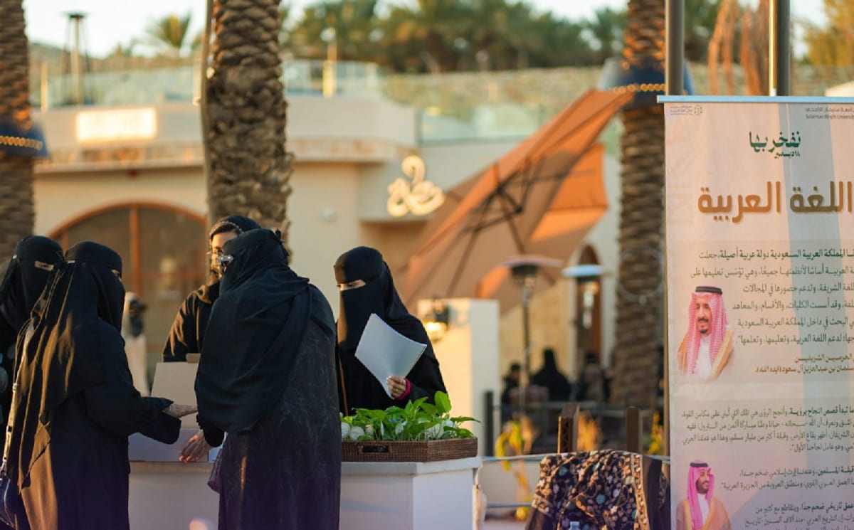 طالبات يستقبلن الزائرات في ركن اليوم العالمي للغة العربية