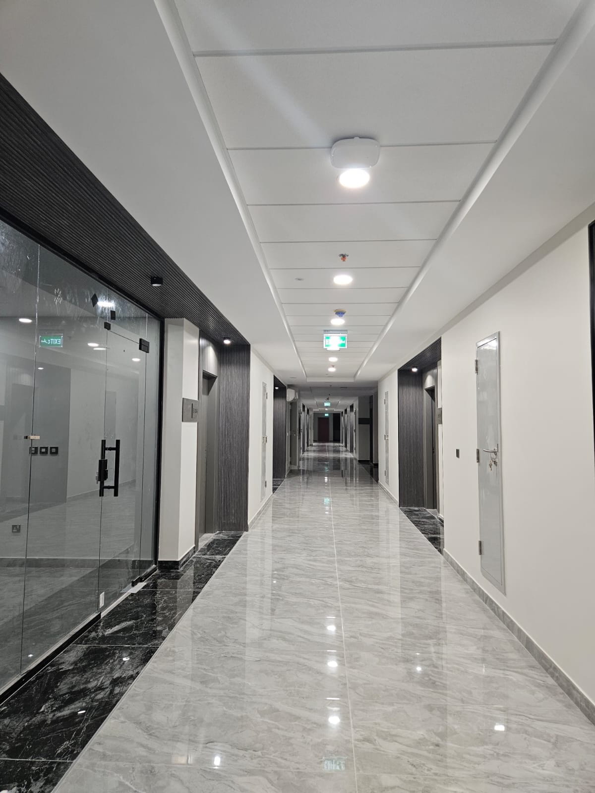 ممرّ في السكن الجامعي بأرضية رخامية وإنارة مدمجة