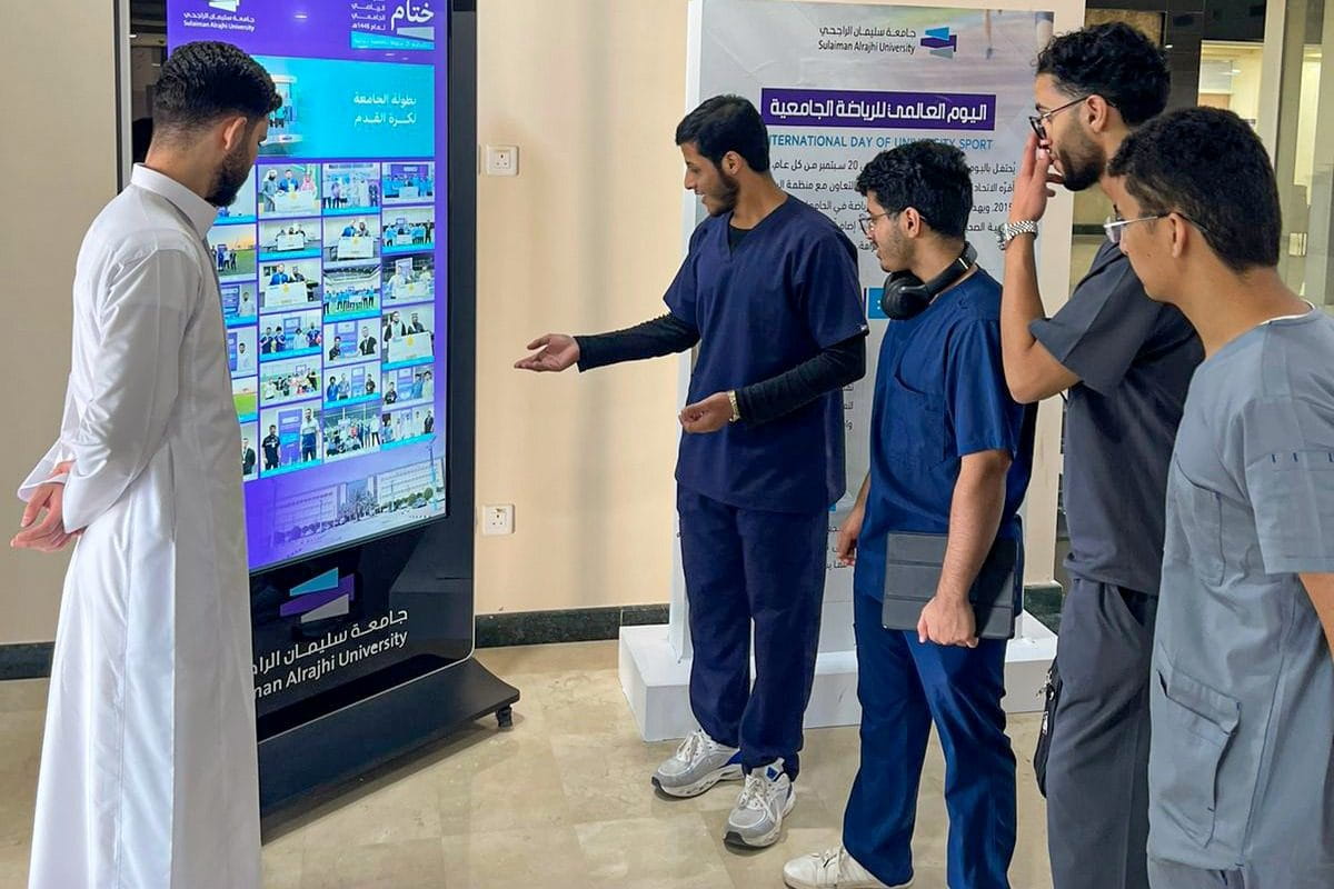 طلبة أمام شاشة تعرض ختام بطولة الجامعة لكرة القدم