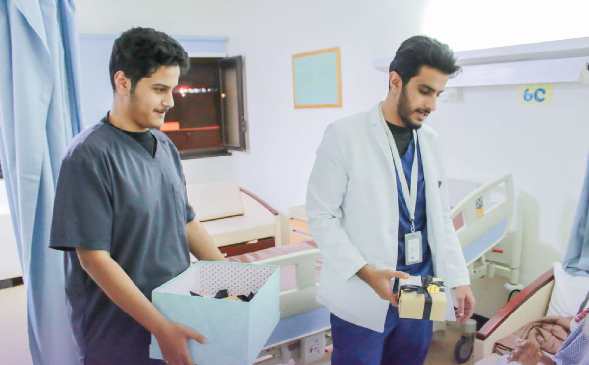 طالبان يحملان هدايا في غرفة مرضى بالمستشفى